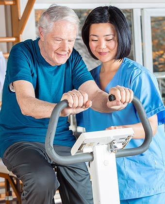 Caregiver helping elderly woman with mobility.