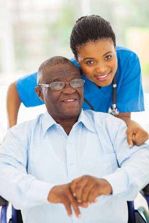 Caregiver giving medication to elderly man